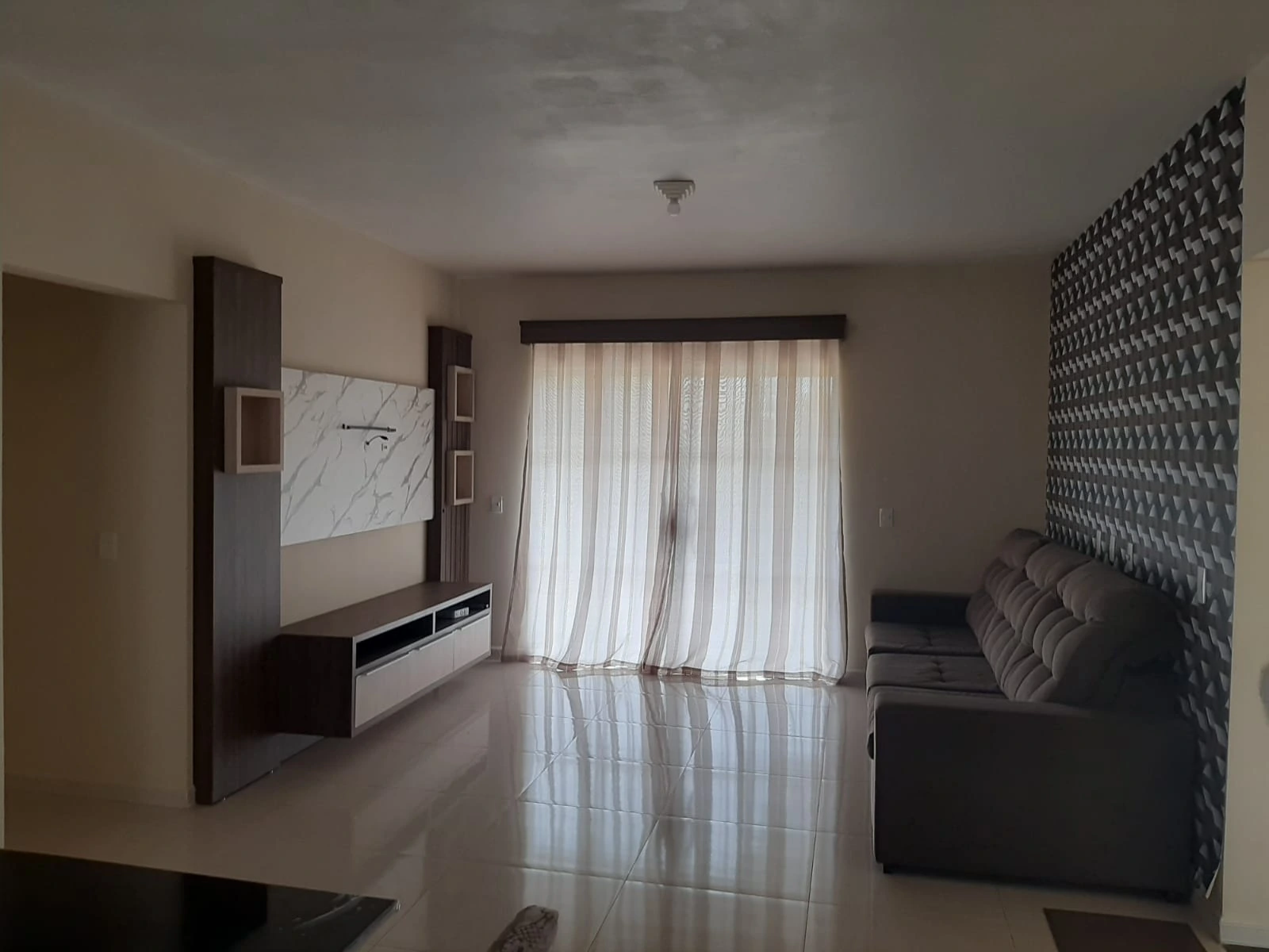 Sala de estar com sofá e painel