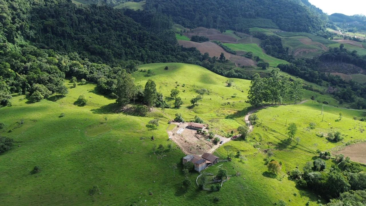 Vista aérea das pastagens, construções e mata da propriedade rural em Presidente Nereu/SC