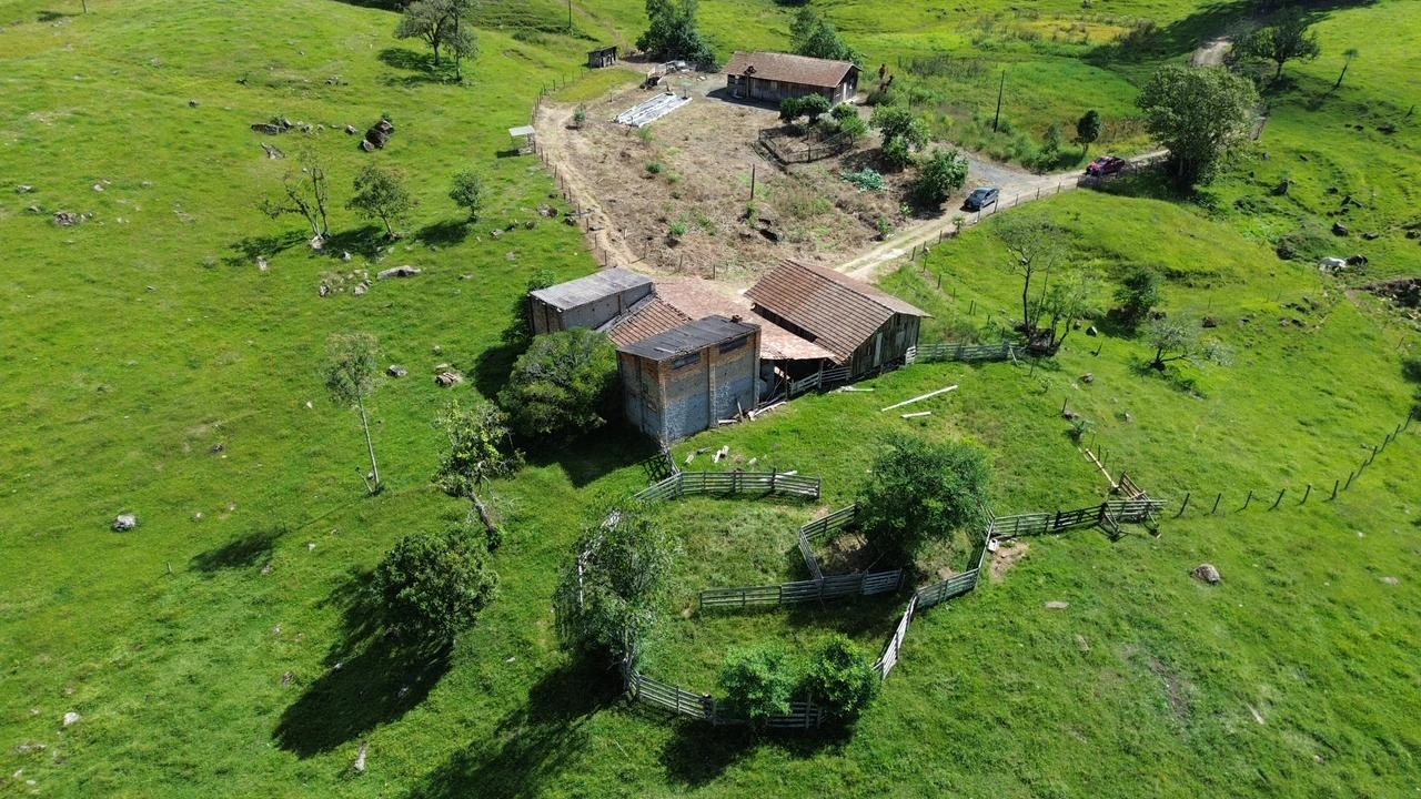 Vista aérea das construções existentes e das pastagens ao redor