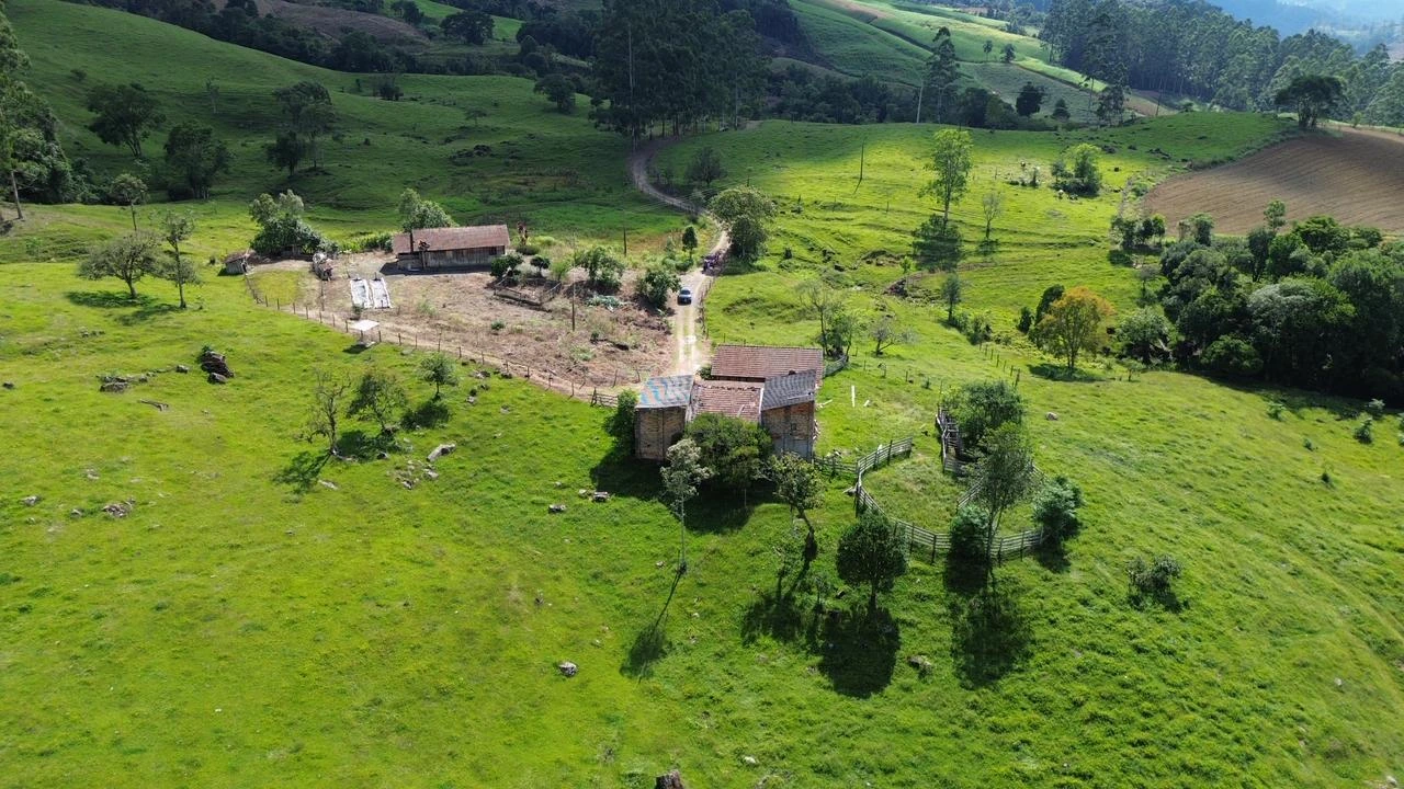 Vista das construções entre as pastagens e as colinas