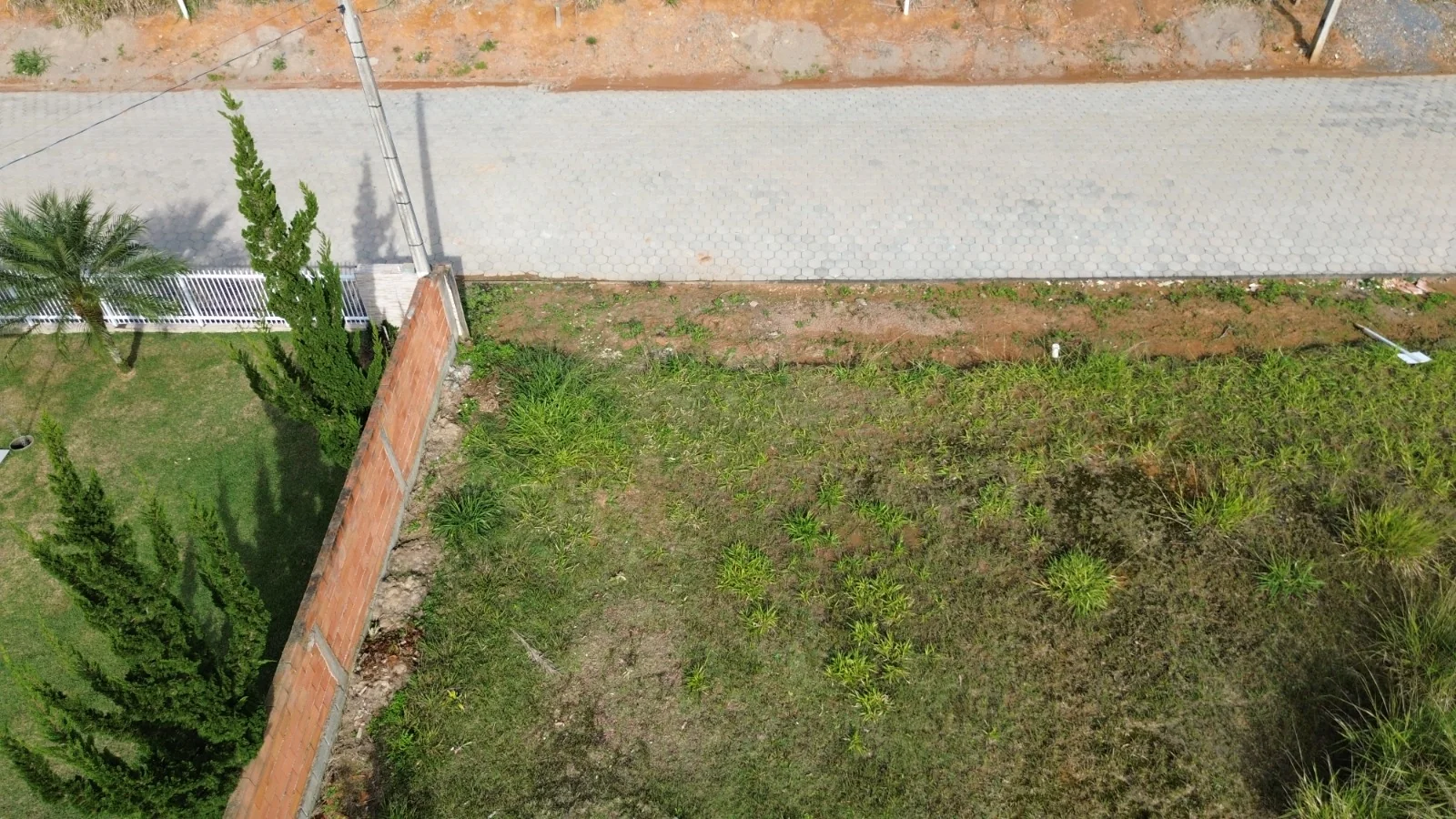 Vista aérea da frente do terreno e da rua pavimentada no Loteamento J. Koch