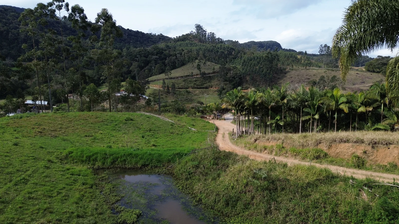 Vista do acesso, da lagoa e da paisagem ao redor do terreno