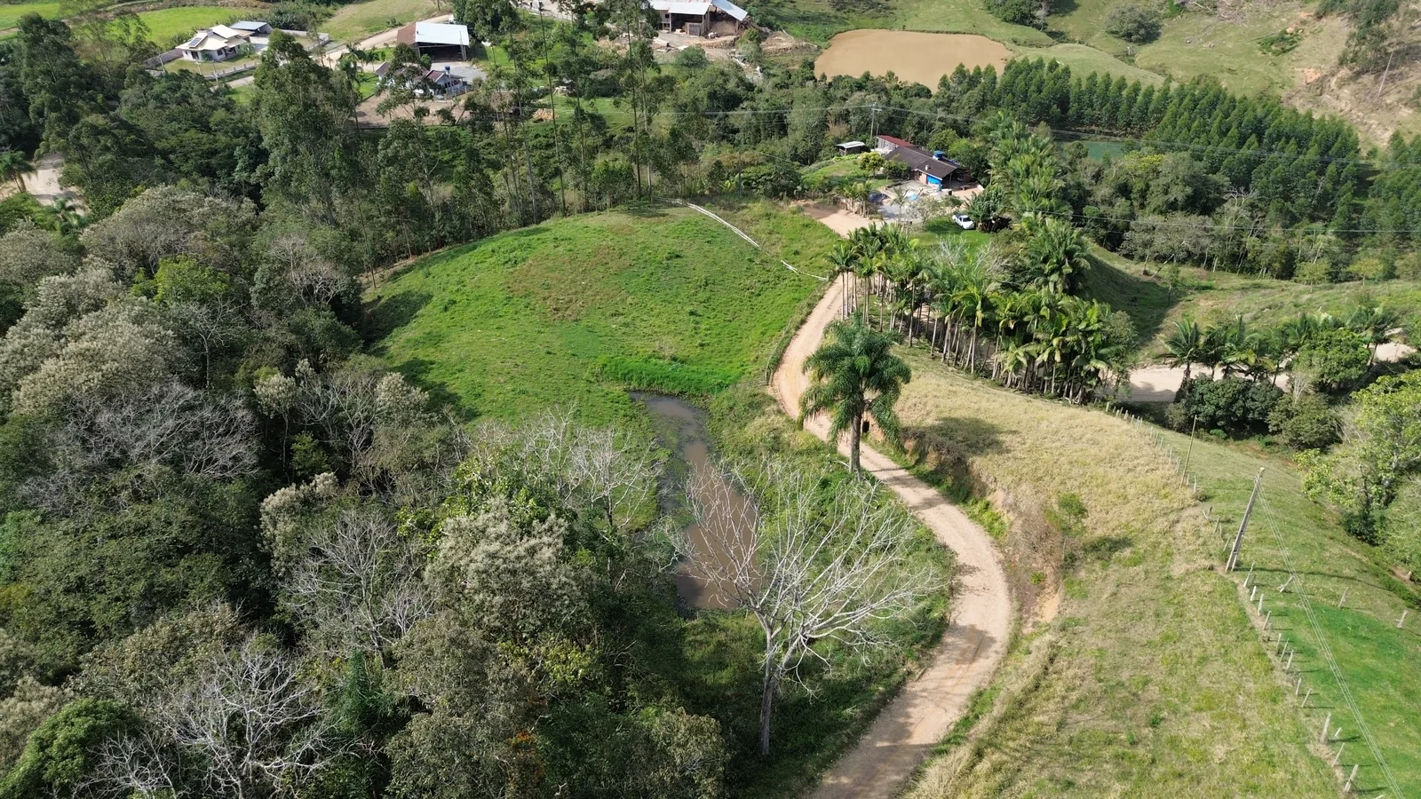 Vista aérea ampla do terreno, da lagoa e da área de pasto em Rio Bandeira